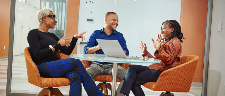 Three BMS employees sitting together at a table