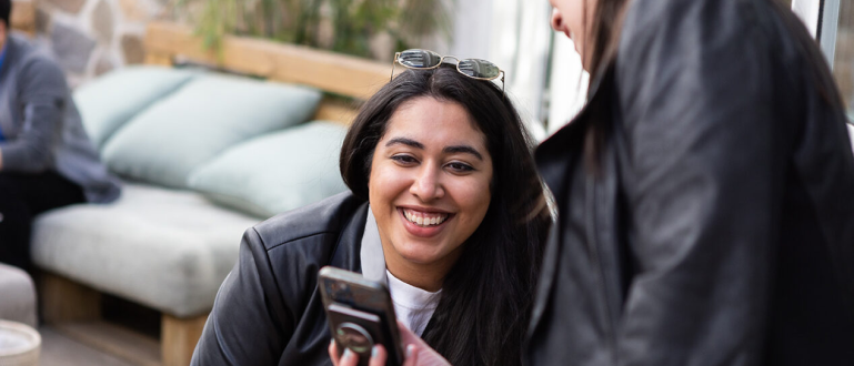 photo of a young woman at a conference looking at a cell phone