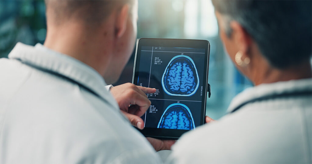 photo of two people looking at brain scans